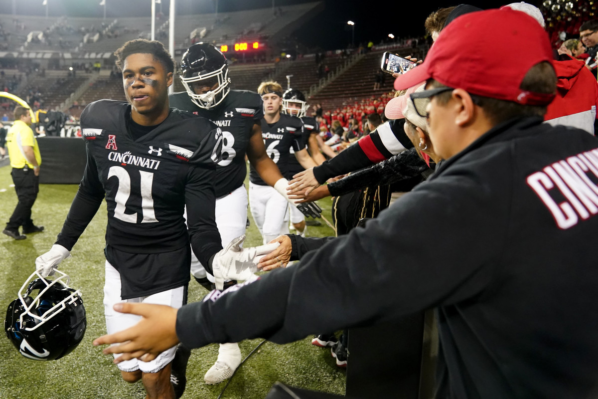 Nov 5, 2022; Cincinnati, Ohio, USA; Cincinnati Bearcats wide receiver Tyler Scott (21) high fives fans after defeating the Navy Midshipmen at Nippert Stadium. Cincinnati won 20-10. Mandatory Credit: Kareem Elgazzar/Cincinnati Enquirer via USA TODAY NETWORK